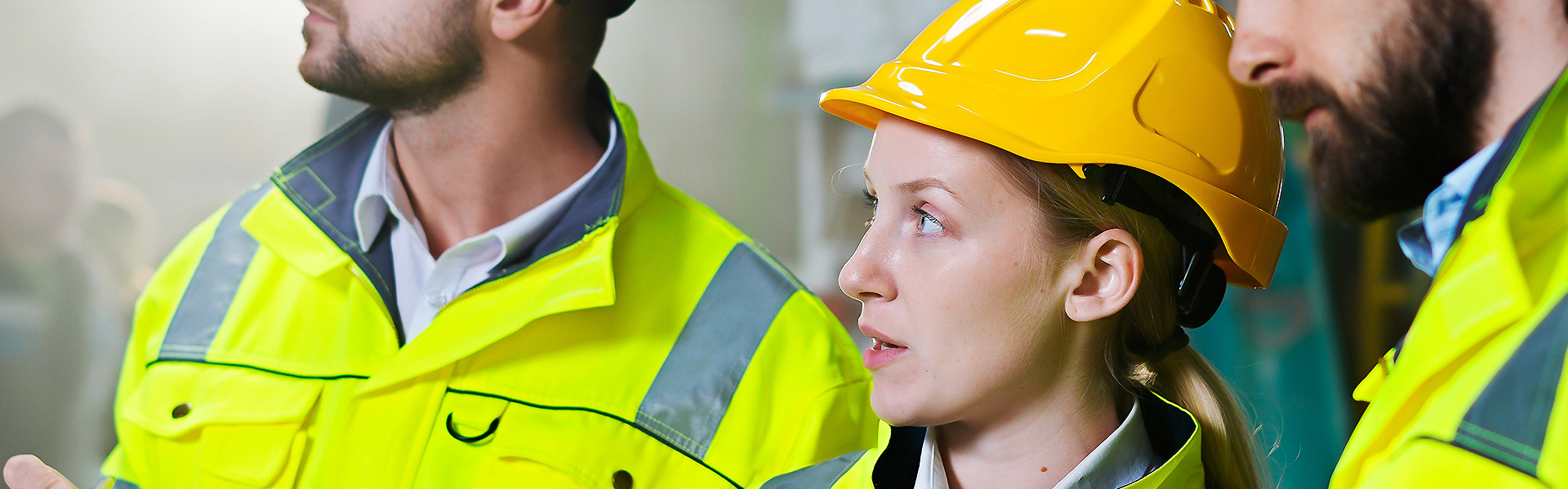 Three people in hard hats and high vis jackets