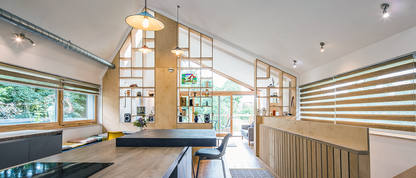 Modern open-plan kitchen and living area with wooden accents, large windows, and geometric shelving. Bright, airy, and minimalist design.